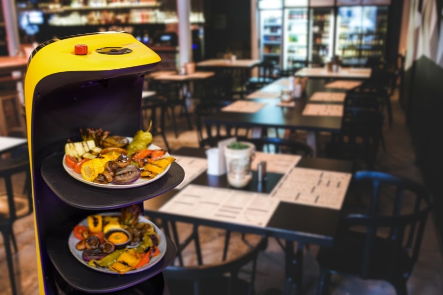 Robot camarero repartiendo platos en un restaurante